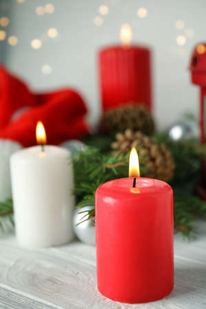 Burning candles on white wooden table against blurred festive lights. Christmas eveの写真素材
