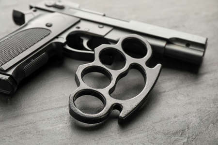 Brass knuckles and gun on black background, closeupの写真素材