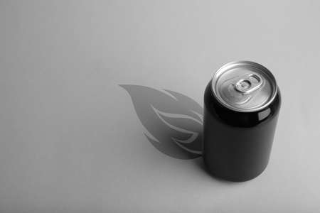 Energy drink and shadow in shape of fire on light gray backgroundの写真素材