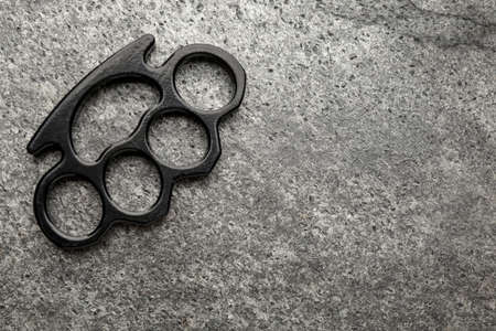 Black brass knuckles on gray background, top view. Space for textの写真素材