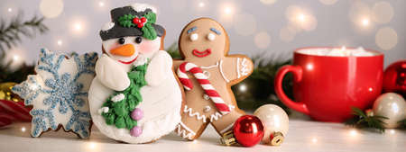 Tasty Christmas cookies and decor on white table against blurred festive lights. Horizontal banner designの写真素材