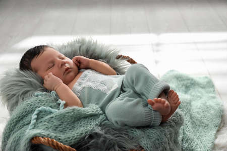 Cute newborn baby sleeping in wicker basket