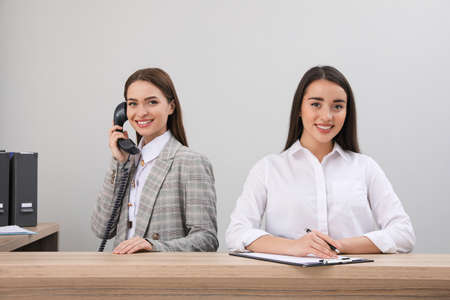 Female receptionists working at desk in hotelの写真素材