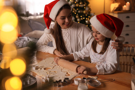 Mother with her cute little daughter making Christmas cookies in kitchenの写真素材