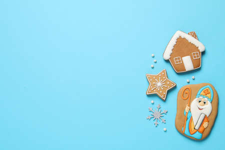 Tasty gingerbread cookies on light blue background, flat lay with space for text. St. Nicholas Day celebrationの写真素材