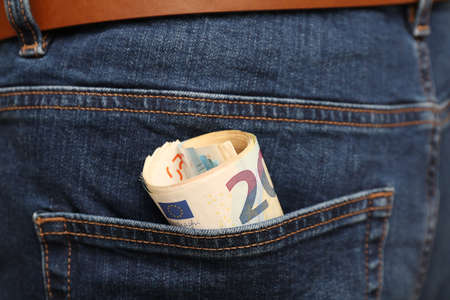 Euro banknotes in pocket of jeans, closeup. Spending money