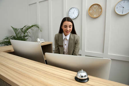Beautiful receptionist working at counter in hotelの写真素材
