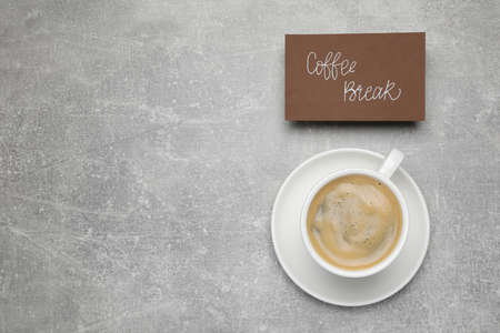 Card with phrase Coffee Break near cup of drink on light gray table, flat lay. Space for textの写真素材