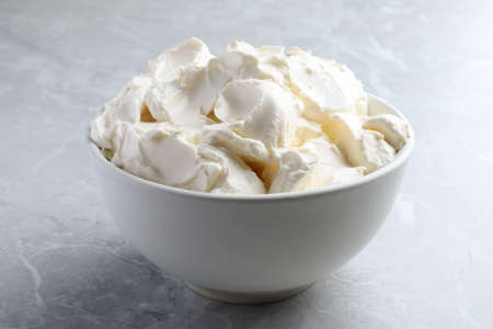 Bowl of tasty cream cheese on light gray marble table, closeupの写真素材
