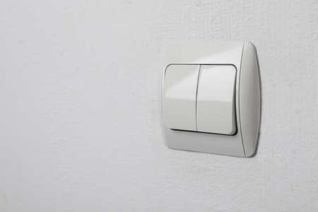 Modern light switch on white wall. Space for textの写真素材