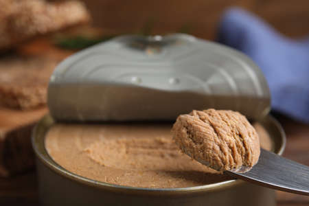 Open tin can with meat pate and knife on table, closeupの写真素材