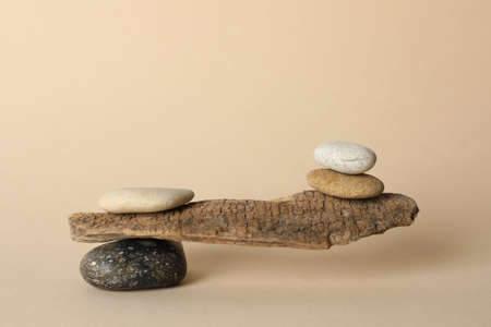Tree branch with stones on beige background. Harmony and balance conceptの写真素材
