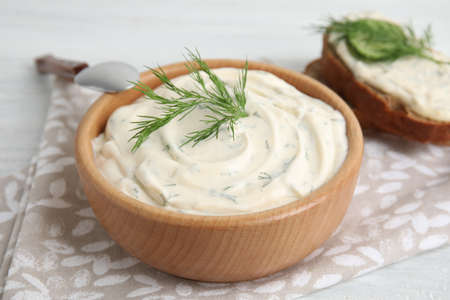 Tasty creamy dill sauce in wooden bowl on table, closeupの写真素材