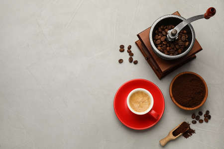 Flat lay composition with coffee grounds and roasted beans on light table, space for textの写真素材