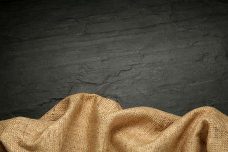 Natural burlap fabric on black table, top view. Space for textの写真素材