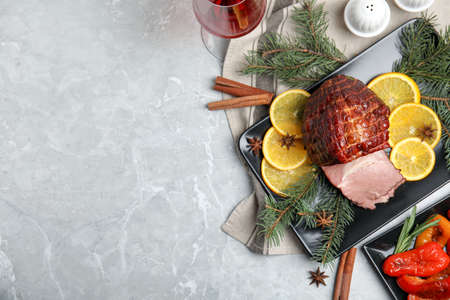 Festive flat lay composition with delicious ham on gray marble table, space for text. Christmas dinnerの写真素材
