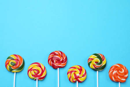 Sweet lollipops on light blue background, flat lay. Space for textの写真素材