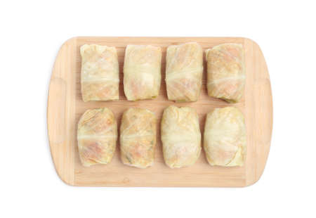 Wooden board with uncooked stuffed cabbage rolls on white background, top viewの写真素材