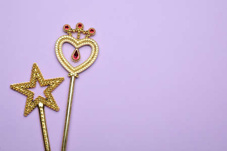 Beautiful golden magic wands on lilac background, flat lay. Space for textの写真素材