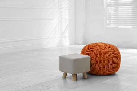 Stylish pouf and ottoman in room, space for textの写真素材
