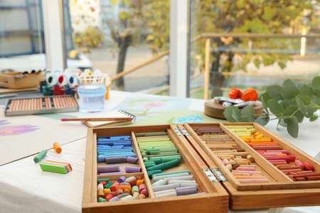 Artist's workplace with drawings, soft pastels and color pencils on table indoorsの写真素材
