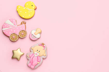 Cute tasty cookies of different shapes on pink background, flat lay with space for text. Baby shower...