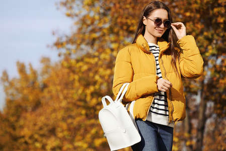 Young woman with stylish backpack on autumn day, space for textの写真素材