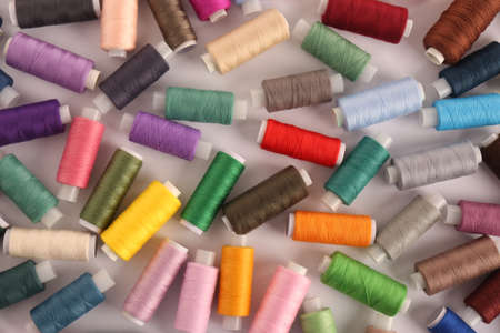 Set of colorful sewing threads on white background, flat lay