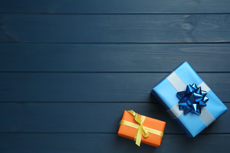 Colorful gift boxes on blue wooden table, flat lay. Space for textの写真素材