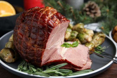 Delicious ham served with brussels sprouts and rosemary on table, closeup. Christmas dinnerの写真素材