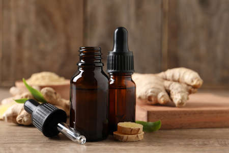 Ginger essential oil in bottles on wooden tableの写真素材