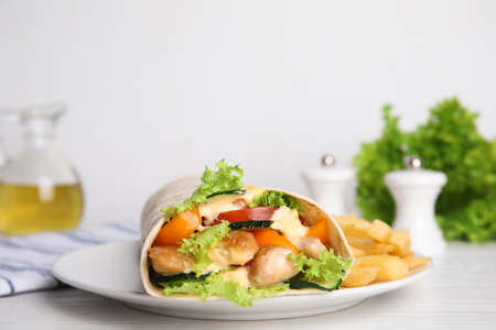 Delicious chicken shawarma and French fries served on white wooden table, closeupの写真素材