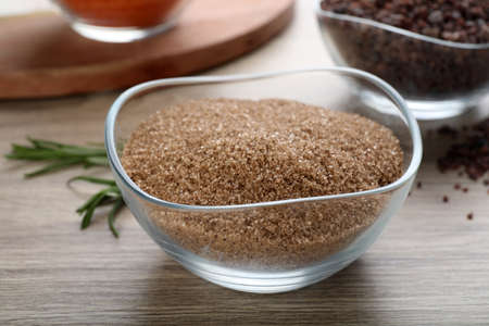 Natural salt in glass bowl on wooden table, closeupの写真素材