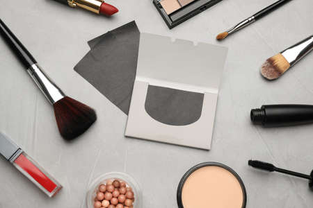 Facial oil blotting tissues and different decorative cosmetics on light gray background, flat lay. Mattifying wipesの写真素材