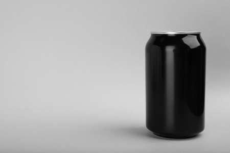 Black can of energy drink on light gray background. Space for textの写真素材