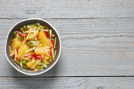 Bowl of delicious turnip soup on gray wooden table, top view. Space for textの写真素材