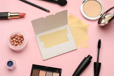 Facial oil blotting tissues and different decorative cosmetics on pink background, flat lay. Mattifying wipesの写真素材
