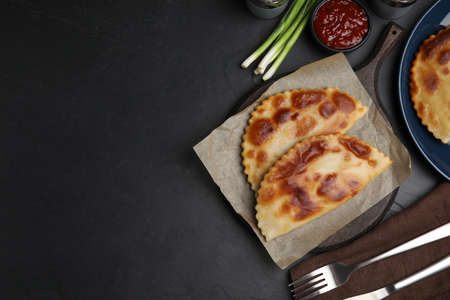 Delicious fried chebureki served on black table, flat lay. Space for textの写真素材