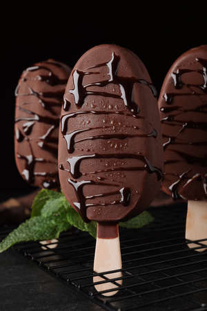 Delicious glazed ice cream bars and mint on black tableの写真素材