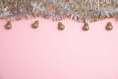 Sparkling tinsel and Christmas balls on pink background, flat lay. Space for textの写真素材