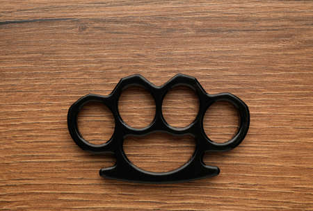 Black brass knuckles on wooden background, top viewの写真素材
