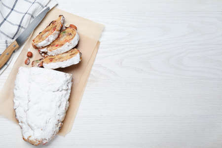 Traditional Christmas Stollen with icing sugar on white wooden table, flat lay. Space for textの写真素材