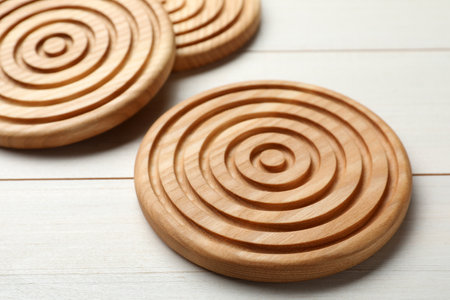 Stylish wooden cup coasters on white tableの写真素材