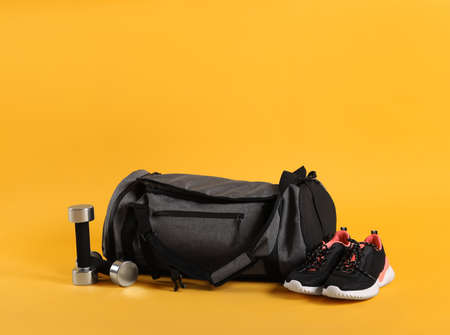 Sports bag and gym equipment on yellow backgroundの写真素材