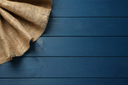Natural burlap fabric on blue wooden table, top view. Space for text