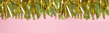 Golden tinsel on pink background, top view. Banner designの写真素材