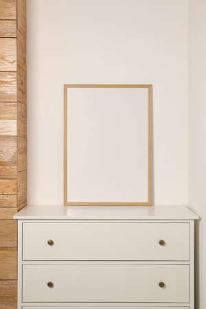 Blank frame on chest of drawers indoors. Space for designの写真素材