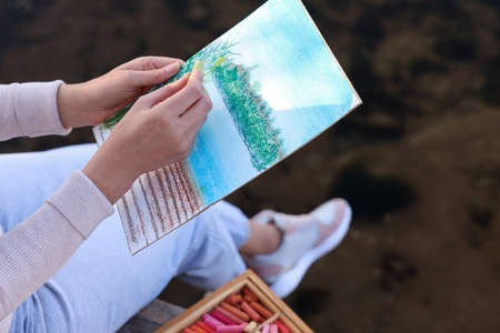 Woman drawing with soft pastels near river, closeupの写真素材