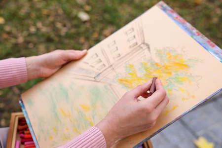 Woman drawing with soft pastels outdoors, closeupの写真素材
