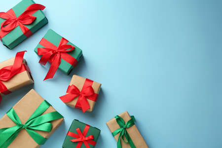 Many gift boxes on light blue background, flat lay. Space for text